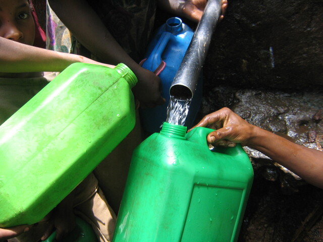 Jerry cans held under a water tap