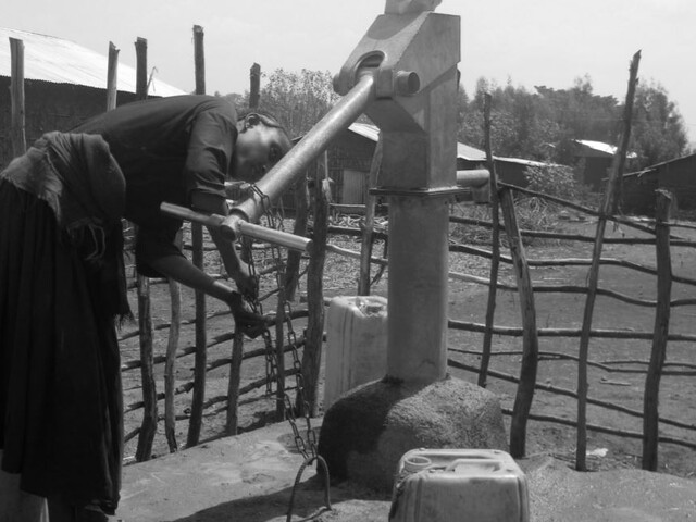 Woman next to hand pump in Ethiopia