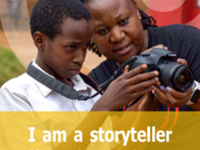Naomi Kabarungi and schoolboy looking at photo camera