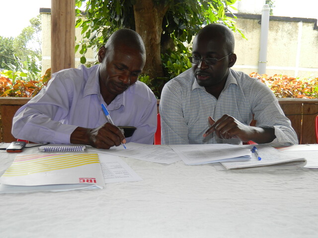 Hand Pump Mechanic Stephen Baryebuga discussing with the District Water officer, Pius Mugabi