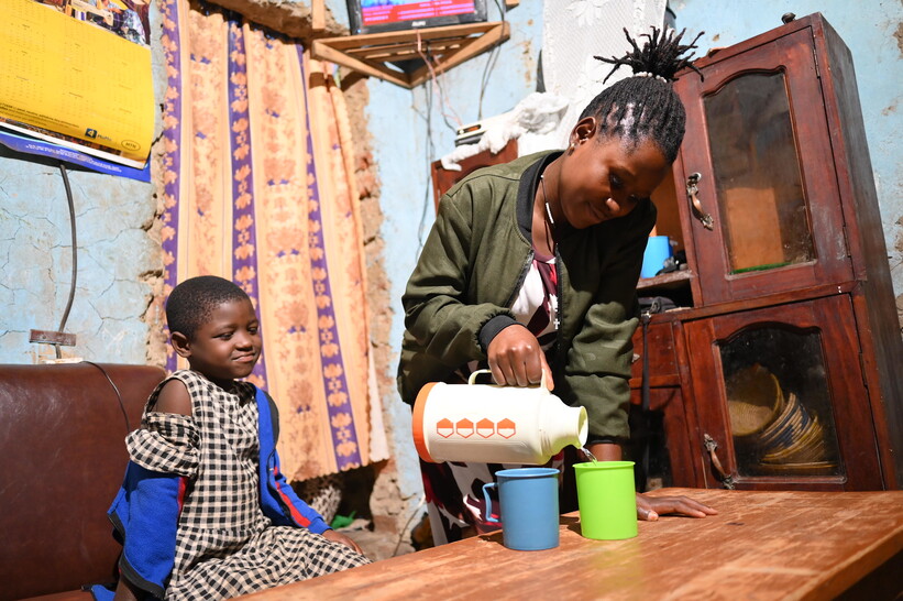 Grace Kansiime and her daughter enjoying safe water from a new household water connection Grace Kansiime and her daughter enjoying safe water from a new household water connection