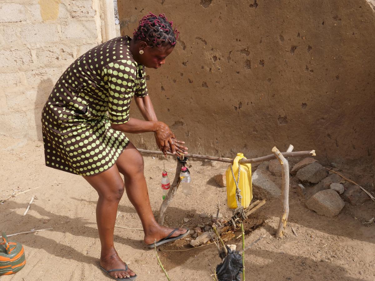 Jennifer Nyaaba, WSMT advocacy team secretary, uses a tippy tap outside her house to wash her hands Jennifer Nyaaba, WSMT advocacy team secretary, uses a tippy tap outside her house to wash her hands