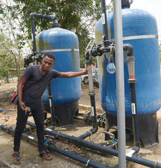 Eric Christford Mensah, CWSA technical engineer, demonstrates the alkaline treatment system that purifies water at Ekutuase