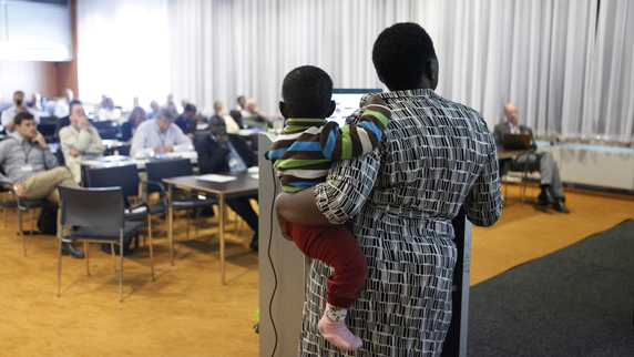 Photo credit: Felix Kalkman Speaker with baby presenting at IRC symposium