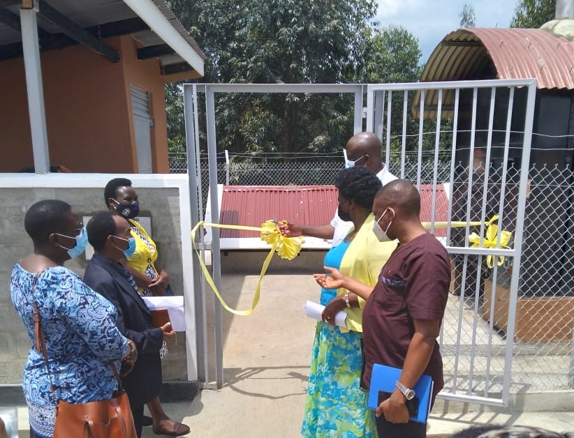 Kabarole Chairman Hon Rwabuhinga cuts the ceremonial tape to launch the new incinerator, with (L-R) Cecilia Birungi, DHI; Alexander Kikwaya, Deputy CAO, Jane Mulumba, IRCJuliana Ayesiga, Resident District Commissioner and Brian Kisembo Acting DHO. Photo by David Ndamira/IRC Uganda.
