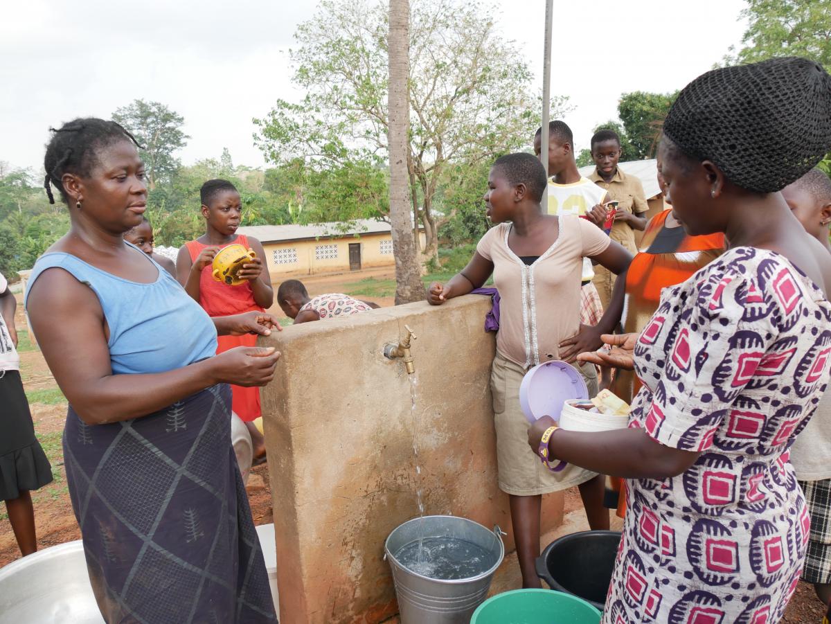 Paying the caretaker at the water point in Ghana