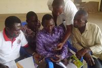 Participants being assisted to use the SMS function on their phone to practise the SMS system