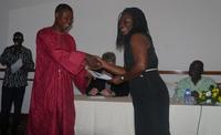 Mrs. Vida Duti, IRC Ghana Country Director, receiving a certificate of recognision from Hon. David Tetteh Assuming, MP for Shai Osudoku and a member of the Parliamentary Select Committee on WRWH