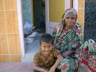 Arjina Khatun and her granddaughter Naher resting outside the female chamber and dressing room